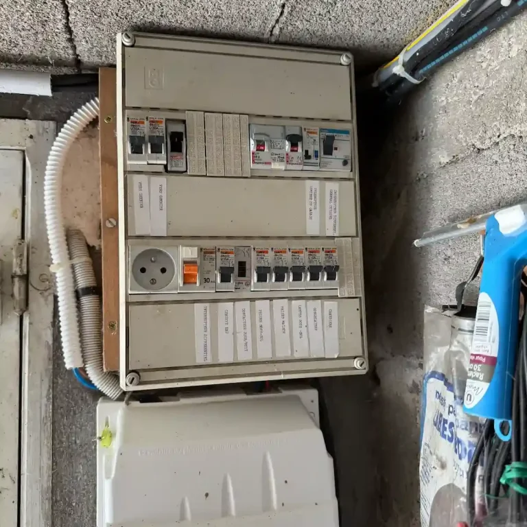 Rénovation d’installation électrique en appartement parisien - Electricien paris services Service Electricien à Paris -Tableau électrique avec plusieurs disjoncteurs et prises en saillie.